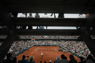 Spectators watch as Austria's Dominic Thiem, in white, as he serves against Bolivia's Hugo Dellien at Simonne Mathieu court during their first round match at the French Open tennis tournament in Roland Garros stadium in Paris, France, Sunday, May 22, 2022. (AP Photo/Thibault Camus)