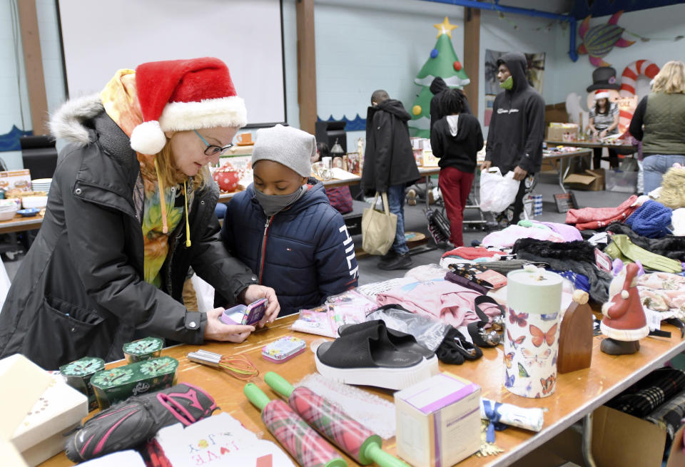 Volunteer Lisa Wrona, left, of Hagerstown, Md., helps Kameron Bolton, 7, of Martinsburg, W.Va., select gifts for his family during Prison Fellowship's Angel Tree event for children of the incarcerated, Sunday Dec. 19, 2021 at Hub City Vineyard church in Hagerstown. The Prison Fellowship's Angel Tree is expected to deliver gifts to about 300,000 kids nationwide this year. (AP Photo/Steve Ruark)