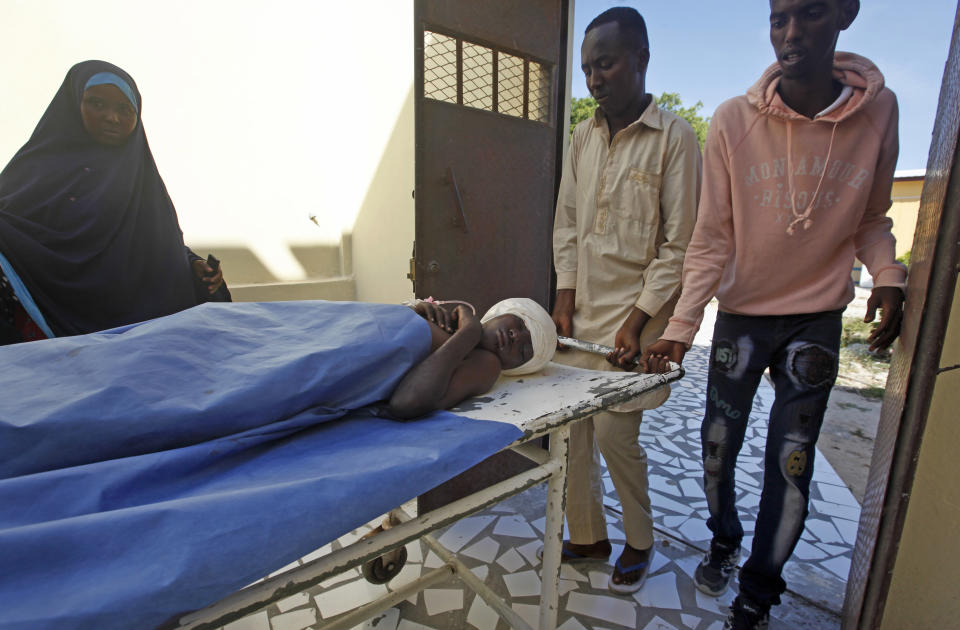 A female relative looks on as a wounded man is brought into Medina Hospital after a car bomb attack at a busy junction in the Wadajir district of the capital Mogadishu, Somalia Monday, Nov. 26, 2018. Somalia was hit by two violent attacks Monday, one killing an Islamic cleric and 17 of his followers for playing music and a second killing at least six people in a car bomb blast in the capital, Mogadishu, police said. (AP Photo/Farah Abdi Warsameh)