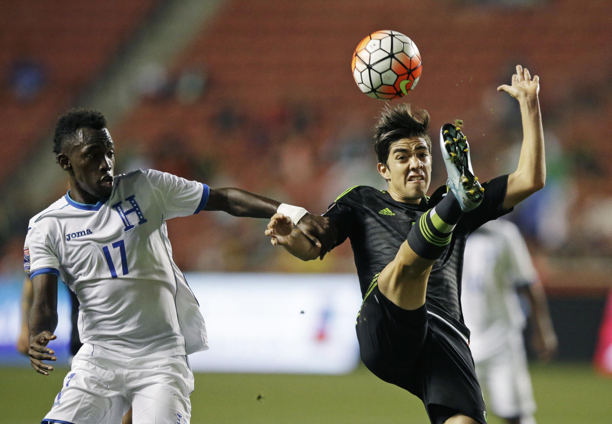 El zaguero mexicano Rodolfo Pizarro despeja frente al delantero hondureño alberth Elis, en la final del Preolímpico de la CONCACAF, realizada el martes 13 de octubre de 2015, en Sandy, Utah (AP Foto/Rick Bowmer)