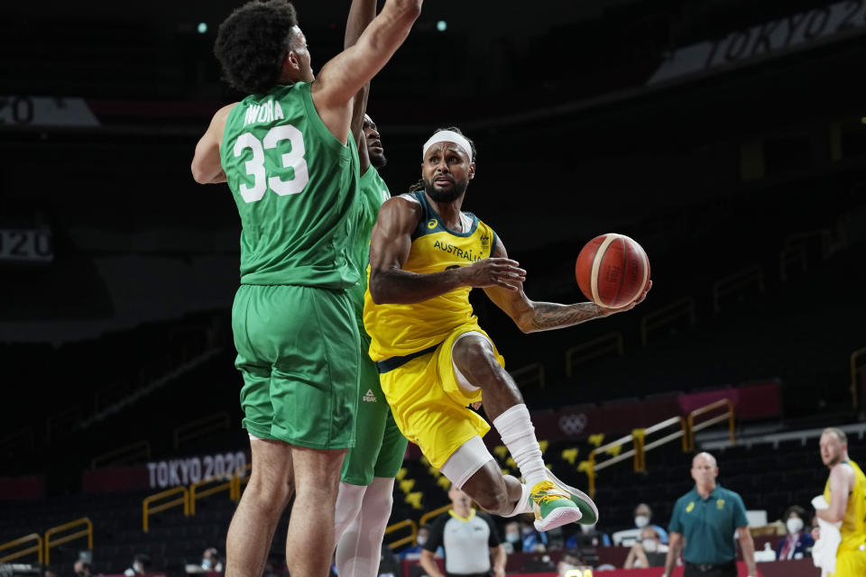 Australia's Patty Mills (5) drives around Nigeria's Jordan Nwora (33) during a men's basketball preliminary round game at the 2020 Summer Olympics, Sunday, July 25, 2021, in Saitama, Japan. (AP Photo/Eric Gay)