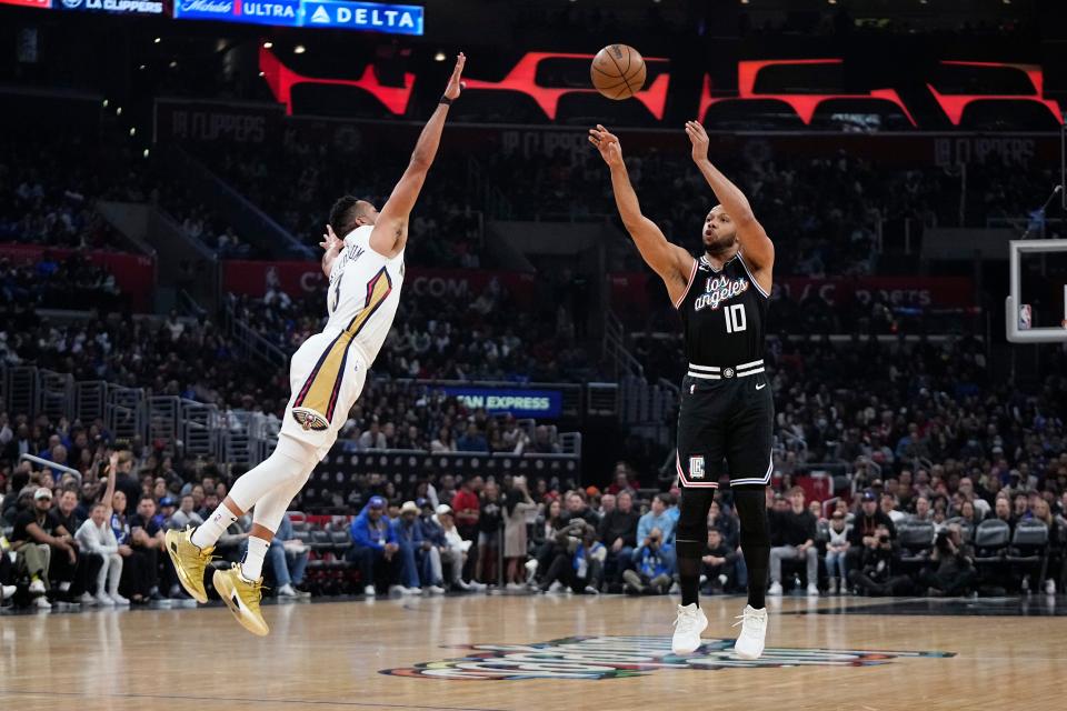 Los Angeles Clippers guard Eric Gordon (right) shoots as New Orleans Pelicans guard CJ McCollum defends during the first half of an NBA basketball game on March 25, 2023, in Los Angeles.