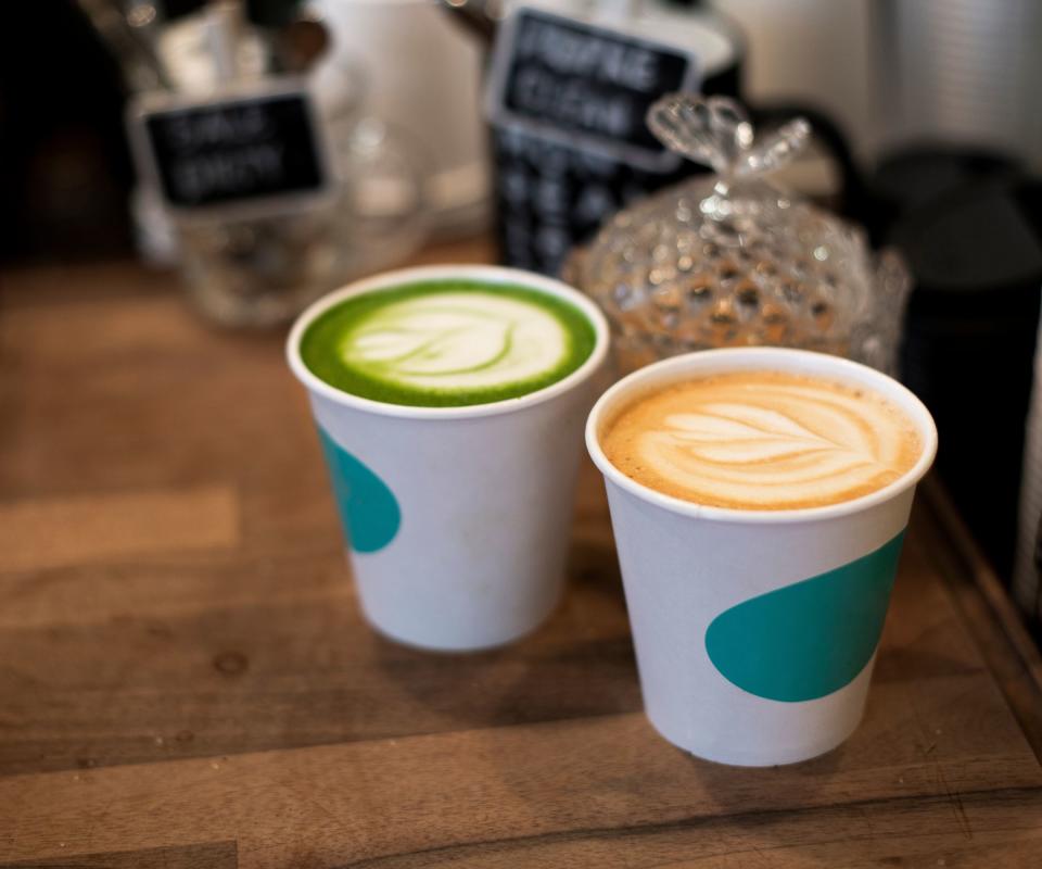 a matcha and a cup of coffee on a serving desk