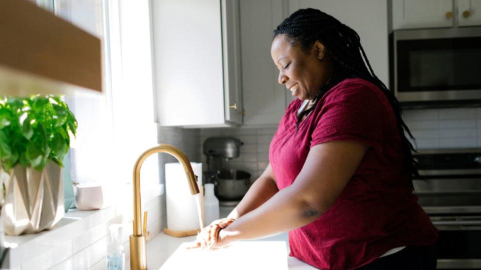 mature woman washing her hands to prevent a summer cold