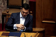 FILE PHOTO: Greek Prime Minister Alexis Tsipras looks at his watch before answering a question on corruption, during the Prime Minister's Question Time at the parliament in Athens, Greece, February 10, 2017. REUTERS/Alkis Konstantinidis/File Photo