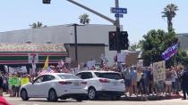 Vehicles travel past people rallying for the U.S. and calling for the end of the lockdown in San Diego, California, amid the coronavirus disease (COVID-19) outbreak in the U.S.