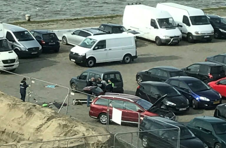 Police stand next to a car after a man tried to drive into a crowd at high-speed in a shopping area in the port city of Antwerp, on March 23, 2017