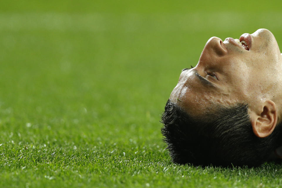 Real Madrid's Angel Di Maria from Argentina lies on the grass during a Spanish La Liga soccer match between Real Madrid and Valencia at the Santiago Bernabeu stadium in Madrid, Spain, Sunday, May 4, 2014 . (AP Photo/Daniel Ochoa de Olza)