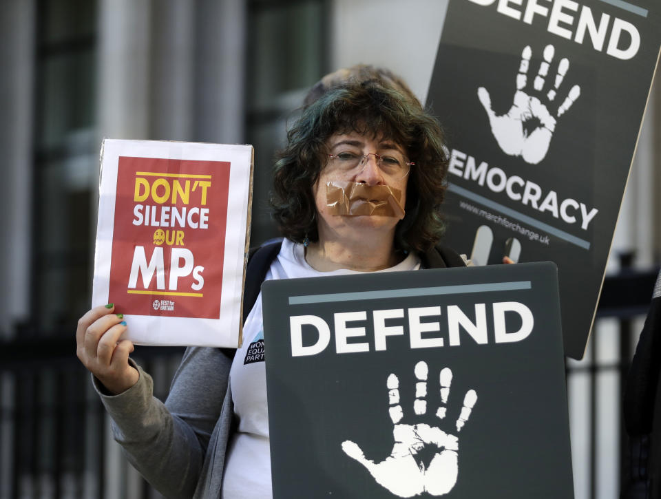 Protesters hold banners outside the Supreme Court in London, Tuesday Sept. 17, 2019. The Supreme Court is set to decide whether Prime Minister Boris Johnson broke the law when he suspended Parliament on Sept. 9, sending lawmakers home until Oct. 14 — just over two weeks before the U.K. is due to leave the European Union. (AP Photo/Matt Dunham)