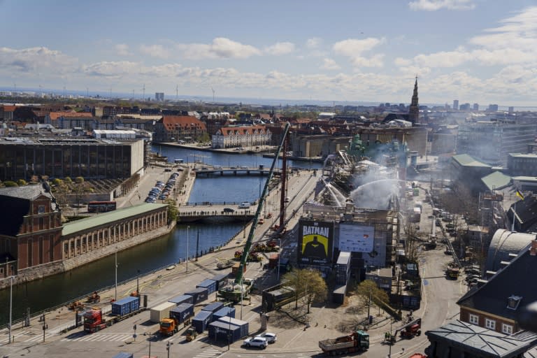 Los bomberos lanzan agua sobre los restos de la antigua Bolsa de Copenhague para tratar de extinguir el incendio, el 17 de abril de 2024 en la capital danesa (Liselotte Sabroe)