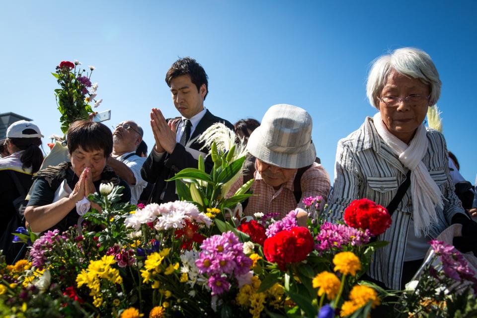 <p>Visitors lays flowers and pray for the atomic bomb victims in front of the cenotaph at the Hiroshima Peace Memorial Park in Hiroshima, western Japan, Sunday, Aug. 6, 2017. (Photo: Richard Atrero de Guzman/NurPhoto via Getty Images) </p>