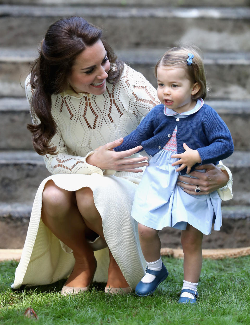 Princess Charlotte, wearing a hand-me-down sweater, with her mother wearing a white Chloe dress. (Photo: Getty Images)