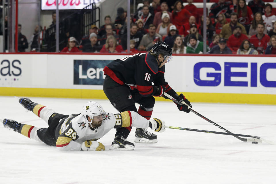 Vegas Golden Knights right wing Alex Tuch (89) dives while chasing the puck with Carolina Hurricanes center Ryan Dzingel (18) during the second period of an NHL hockey game in Raleigh, N.C., Friday, Jan. 31, 2020. (AP Photo/Gerry Broome)