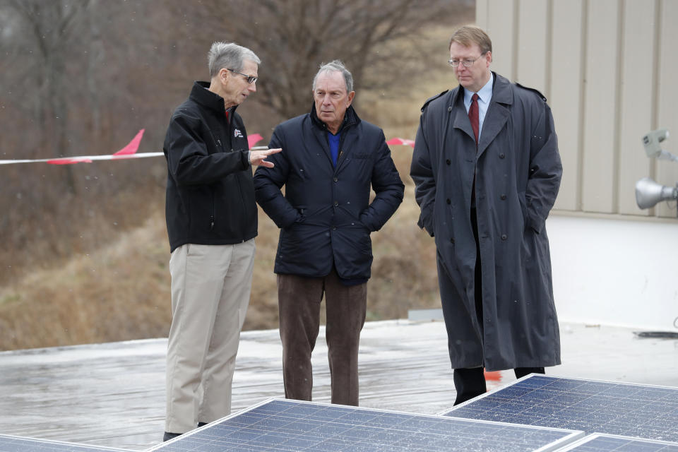 Former New York Mayor Michael Bloomberg, center, looks at solar panels with former Paulson Electric Company president Ron Olson, left, and Iowa State Sen. Rob Hogg, D-Cedar Rapids, right, Tuesday, Dec. 4, 2018, in Cedar Rapids, Iowa. (AP Photo/Charlie Neibergall)