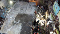 This photograph provided by India’s National Disaster Response Force (NDRF) shows rescuers at the site after a residential building collapsed in Bhiwandi in Thane district, a suburb of Mumbai, India, Monday, Sept.21, 2020. (National Disaster Response Force via AP)