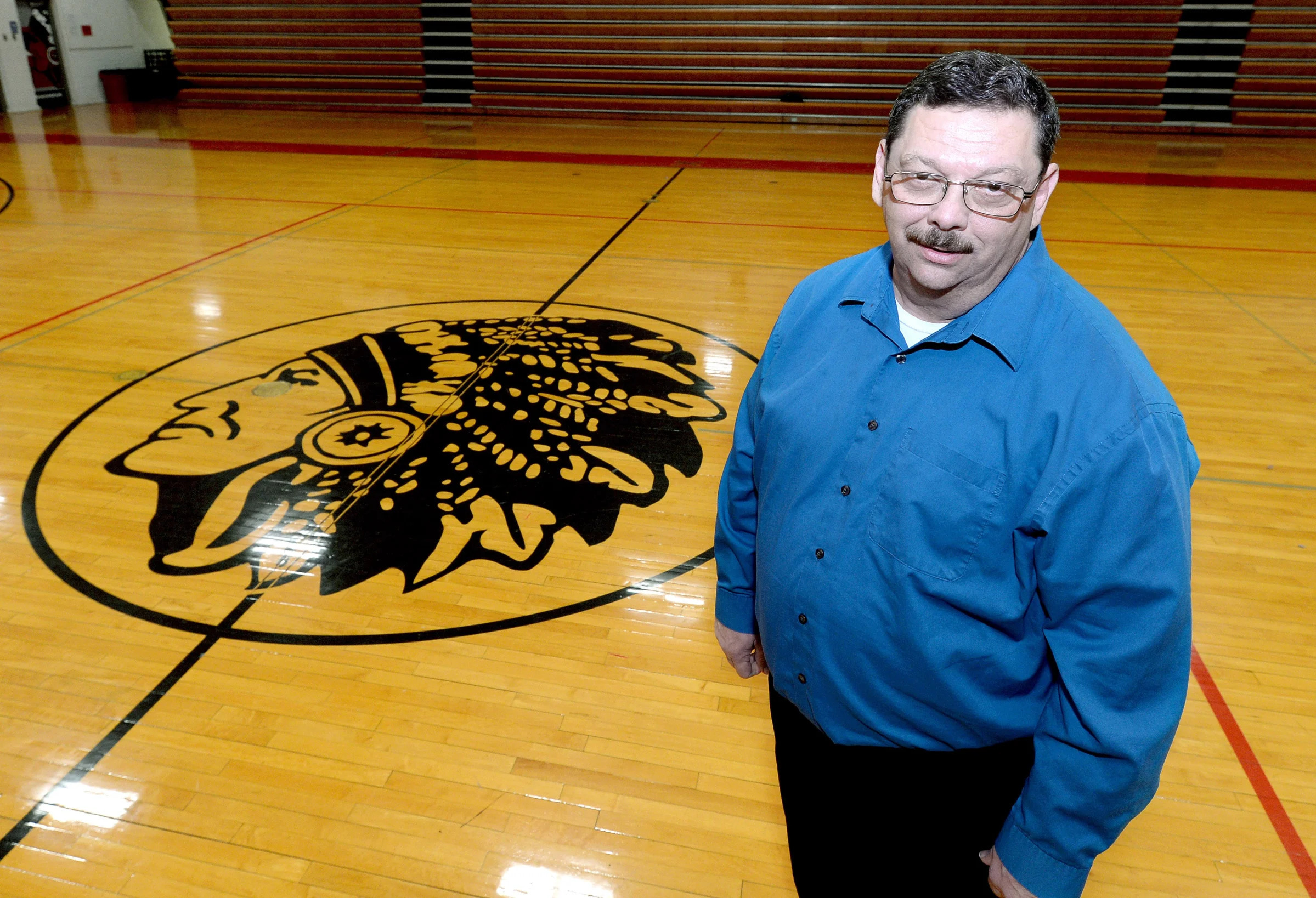 Nokomis School District Superintendent Scott Doerr stands with an image of the school mascot on one of the gym floors at the school Wednesday, March 27, 2024.