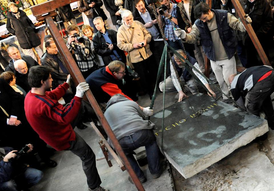 a group of people standing around a small crane.  The crane has a raised stone slab bearing the name tycho brahe