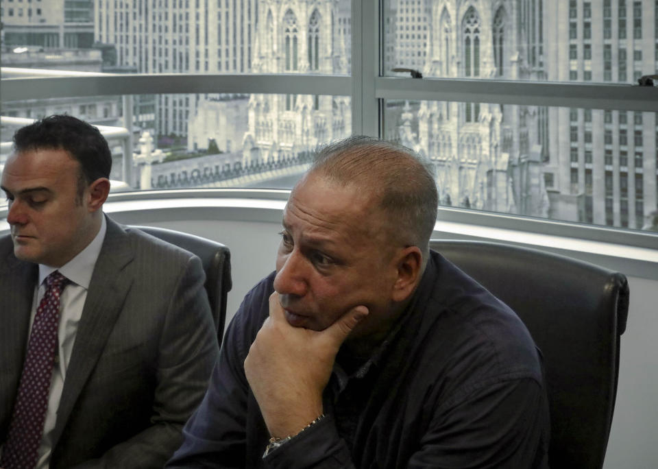 In this Tuesday, Oct. 29, 2019, photo, Ramon Mercado, right, recalls childhood clergy sexual abuse while his lawyer, Adam Slater, left, takes notes during an interview in his office overlooking St. Patrick's Cathedral, in New York. Mercado said he kept silent about the abuse he suffered at the hands of a New York priest, in part not to upset his devout Catholic mother. (AP Photo/Bebeto Matthews)