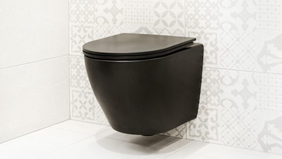 black hanging toilet against white wall modern wall mounted toilet in a tiled bathroom interior