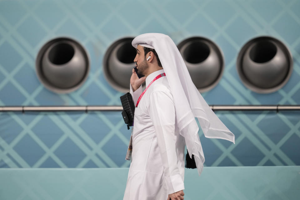 FILE - A man speaks on phone as he walk in front of giant air conditioning during the World Cup group A soccer match between Netherlands and Ecuador, at the Khalifa International Stadium in Doha, Qatar, Friday, Nov. 25, 2022. An advertising regulator says FIFA made false claims about last year's World Cup in Qatar being carbon neutral. The Swiss Commission for Fairness says FIFA was “not able to provide proof that the claims were accurate.” (AP Photo/Natacha Pisarenko, File)