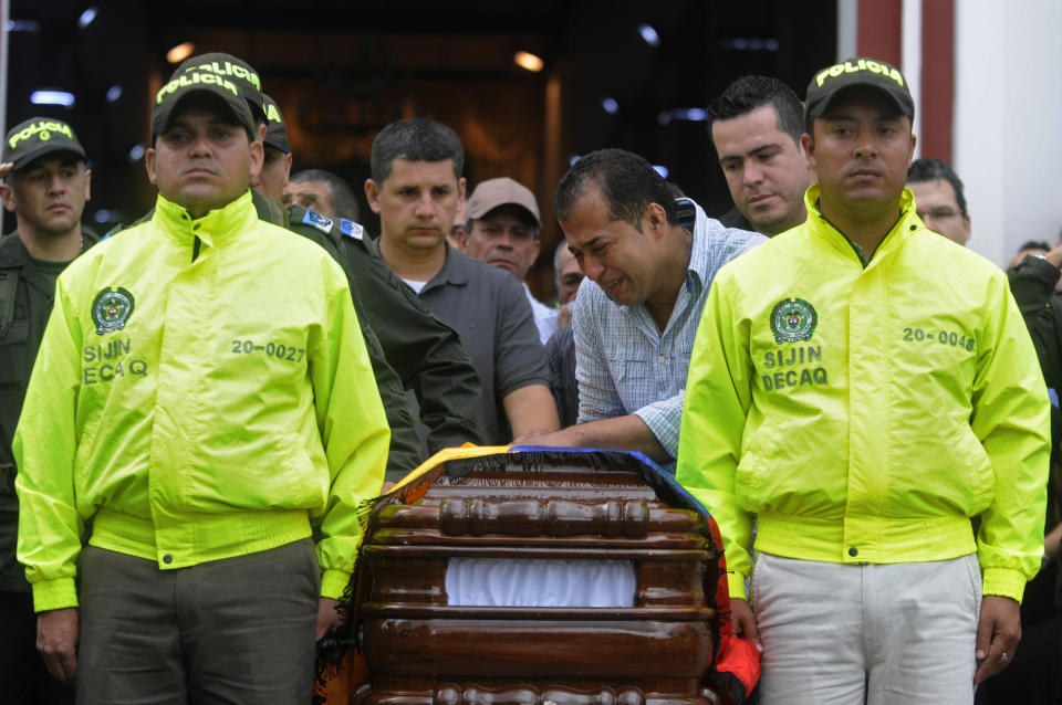 Relatives and fellow police officers carry the coffin containing the body of police officer Andres Rodriguez during his funeral service in Guarne, Colombia, Monday, April 30, 2012. Colombia's Defense Minister Juan Carlos Pinzon said his government has not launched any special rescue mission for Romeo Langlois, a French journalist who was accompanying a counterdrug mission when it was attacked by leftist rebels on Saturday, killing Rodriguez. (AP Photo/Luis Benavides)