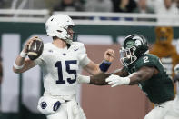 Penn State quarterback Drew Allar (15) is pressured by Michigan State defensive lineman Khris Bogle (2) during the first half of an NCAA college football game, Friday, Nov. 24, 2023, in Detroit. (AP Photo/Carlos Osorio)