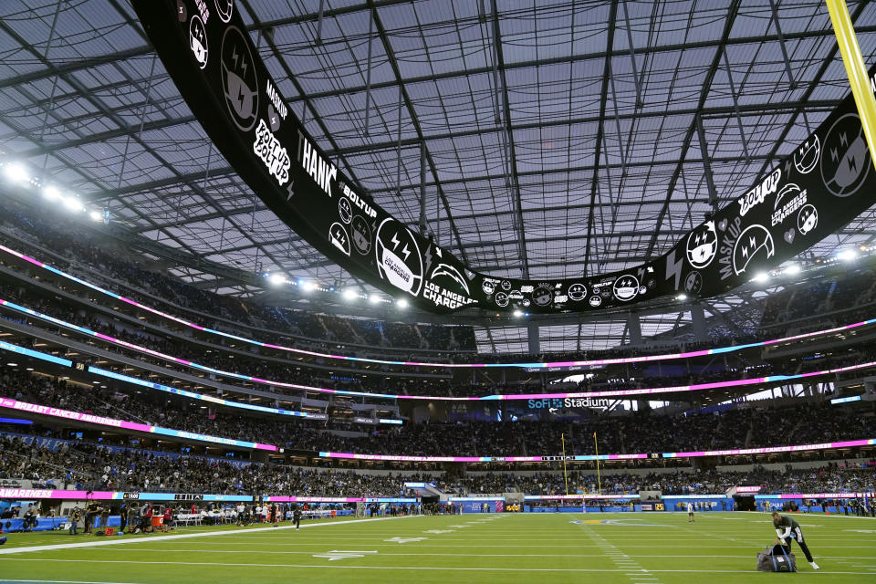 Players leave the field at SoFi Stadium during a weather delay shortly before the scheduled start of an NFL football game between the Los Angeles Chargers and the Las Vegas Raiders, Monday, Oct. 4, 2021, in Inglewood, Calif. (AP Photo/Marcio Jose Sanchez)