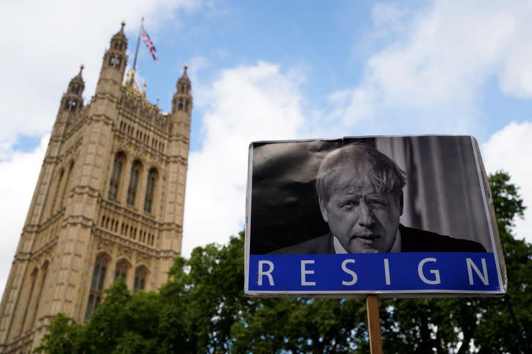 Una fotografía tomada el 6 de junio de 2022 muestra una pizarra en la que se lee "Dimisión" y en la que aparece el primer ministro británico, Boris Johnson, frente a la Cámara del Parlamento, en Londres, mientras se enfrenta a una moción de censura por parte de los miembros del partido conservador.