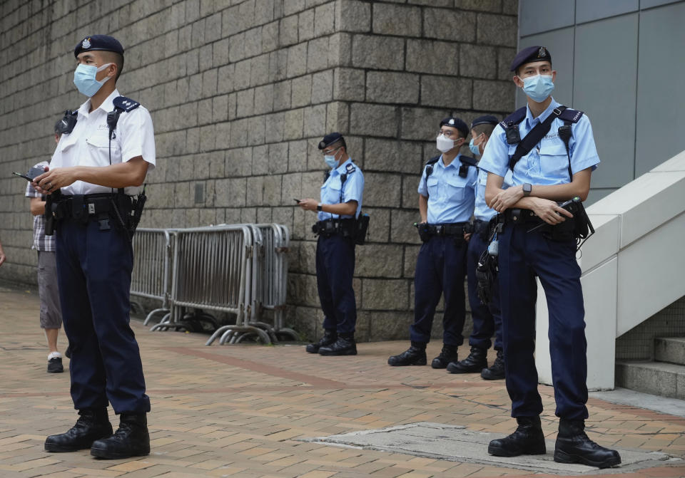 Police officers stand guard as they wait for Tong Ying-kit to leave a court in Hong Kong Tuesday, July 27, 2021. Tong, 24, the first person to be tried under Hong Kong’s sweeping national security law was found guilty of secessionism and terrorism on Tuesday in a ruling condemned by human rights activists. (AP Photo/Vincent Yu)