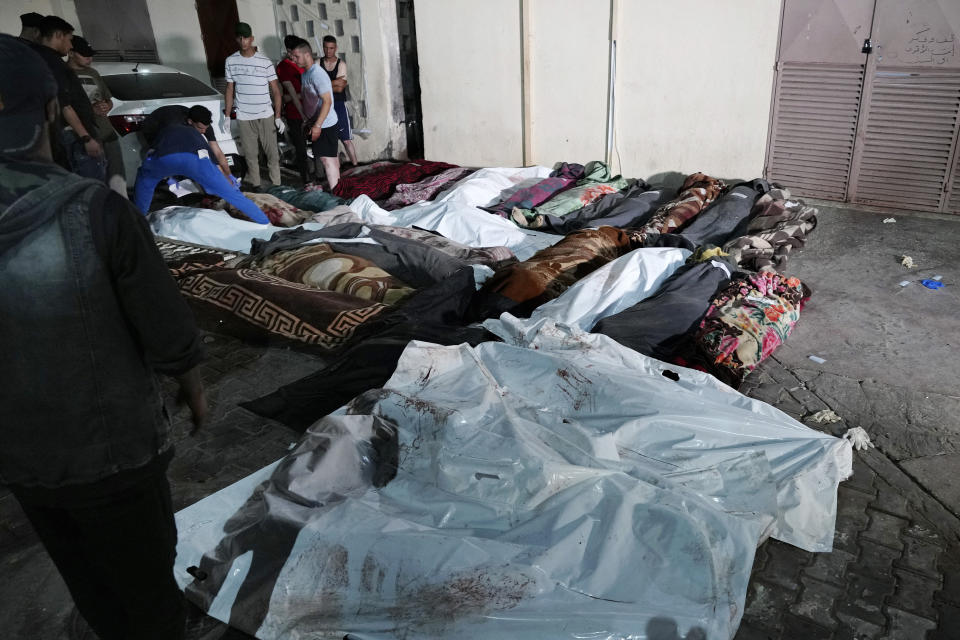Palestinians check the bodies of their relatives killed in an Israeli bombardment of UNRWA school at Nusseirat refugee camp, in front of the morgue of al-Aqsa Martyrs hospital in Deir al-Balah, central Gaza Strip, early Thursday, June 6, 2024. (AP Photo/Abdel Kareem Hana)