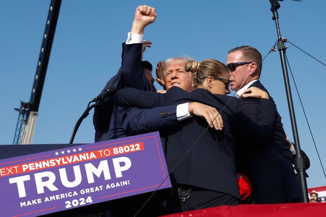 <p>Anna Moneymaker/Getty</p> Donald Trump pumps his fist in the air before he is rushed off stage during a rally on July 13, 2024