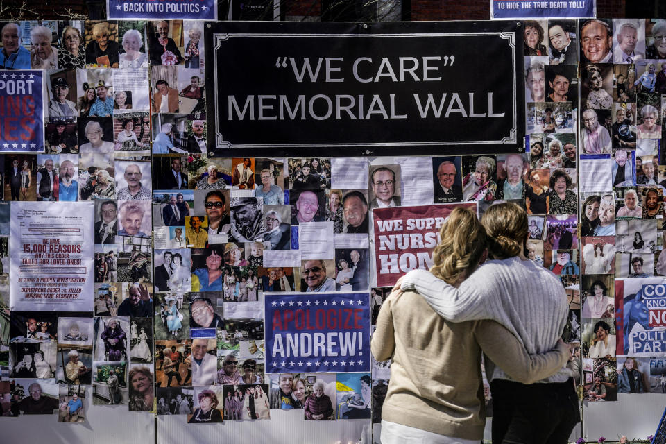 FILE - In this file photo, Theresa Sari, left, and her daughter Leila Ali look at a protest-memorial wall for nursing home residents who died from COVID-19, including Sari's mother Maria Sachse, March 21, 2021, in New York. A state Assembly committee investigation found former New York Gov. Andrew Cuomo's administration made a political decision to misrepresent how many nursing home residents died of COVID-19. (AP Photo/Seth Wenig, File)
