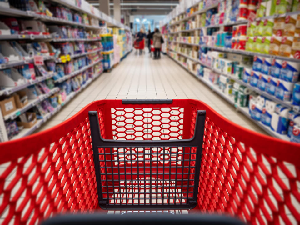 A grocery cart in a supermarket aisle