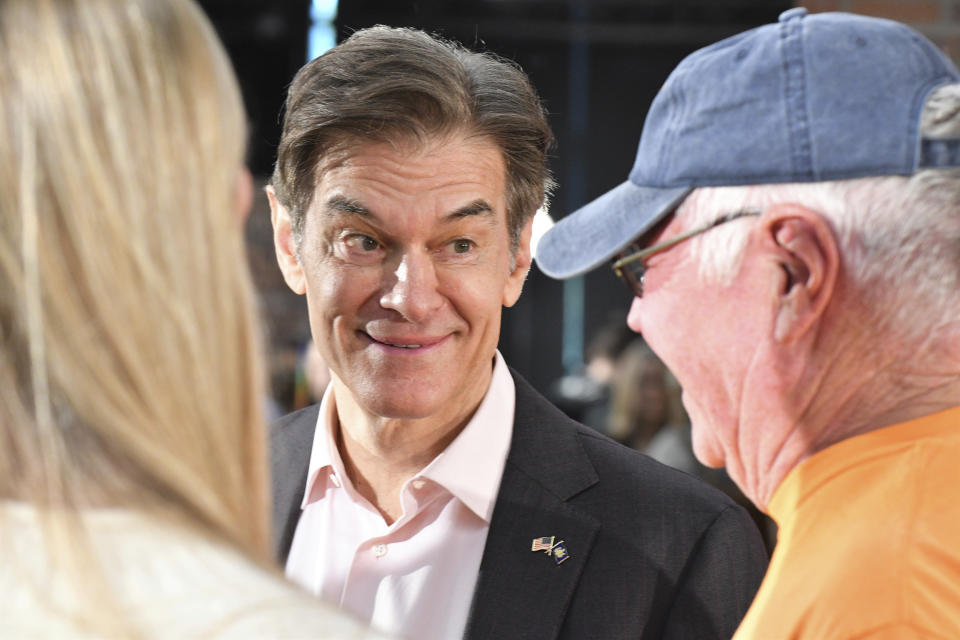 Mehmet Oz, the TV celebrity and heart surgeon who is running for the Republican nomination for U.S. Senate in Pennsylvania, talks with attendees Bob and Eileen Walker after Oz spoke at a town hall-style event at the Newtown Athletic Club, Feb. 20, 2022, in Newtown, Pa. (AP Photo/Marc Levy)