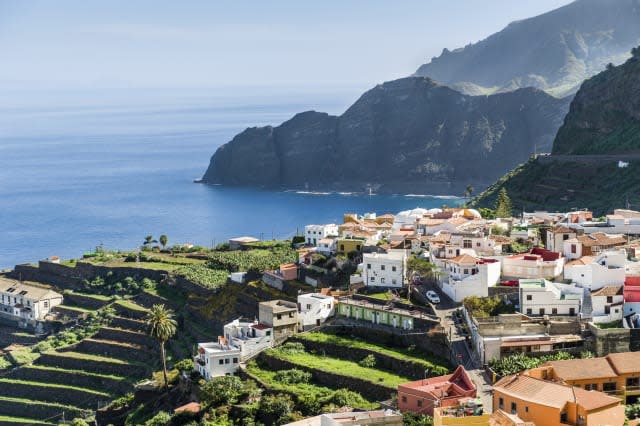 Village at Atlantic ocean shore and high rocks.