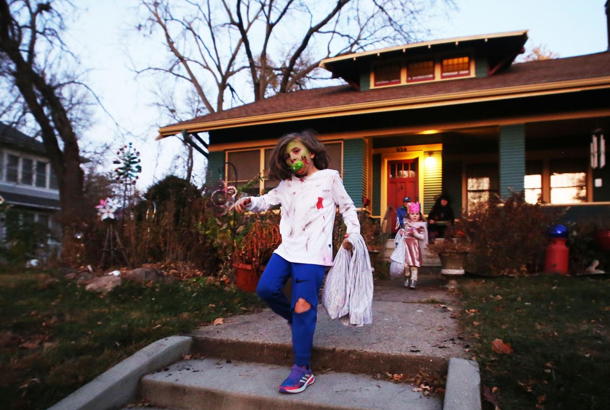 Ari Amman, 8, trick-or-treats at the Hodge Avenue on  Halloween night on Monday, Oct. 31, in Ames, Iowa.