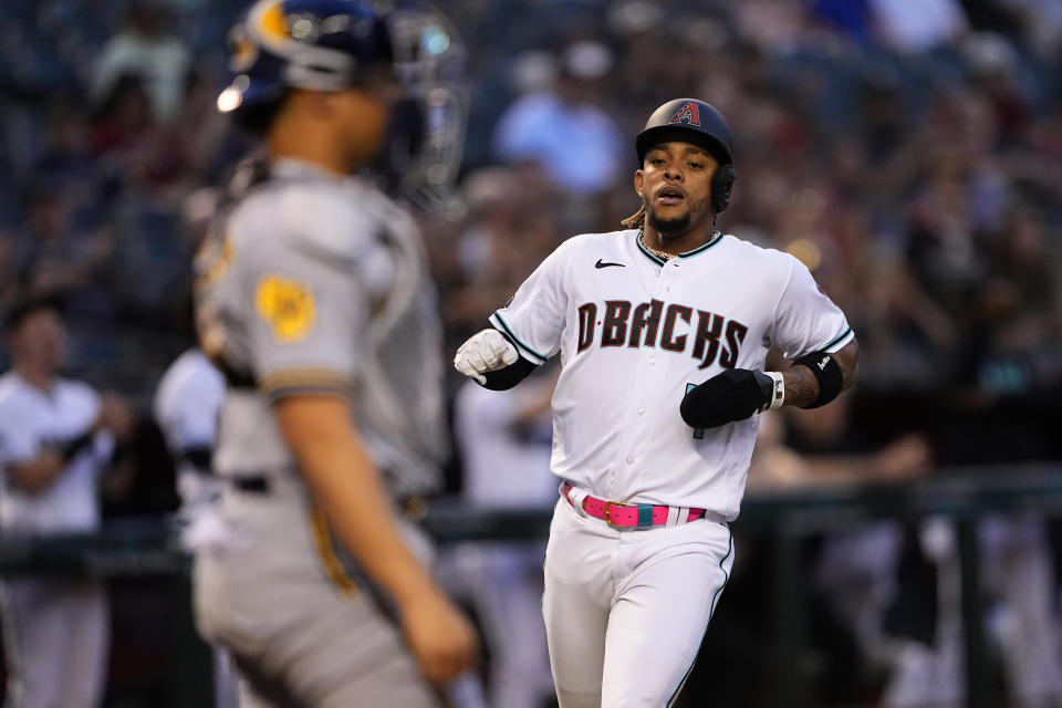 Arizona Diamondbacks' Ketel Marte scores on a base hit by Josh Rojas during the first inning of a baseball game against the Milwaukee Brewers', Monday, April 10, 2023, in Phoenix. (AP Photo/Matt York)