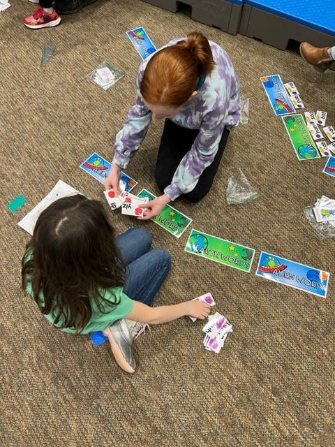 Students practice their reading skills as part of one of several games available to participants at Math and Literacy Night.