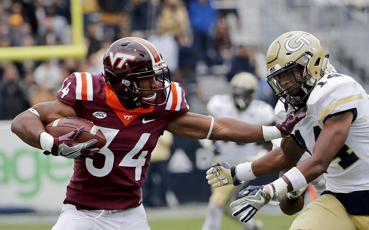 Virginia Tech’s Travon McMillian, left, runs the ball against Georgia Tech’s Corey Griffin in the second quarter of an NCAA college football game in Atlanta, Saturday, Nov. 11, 2017. (AP Photo/David Goldman)