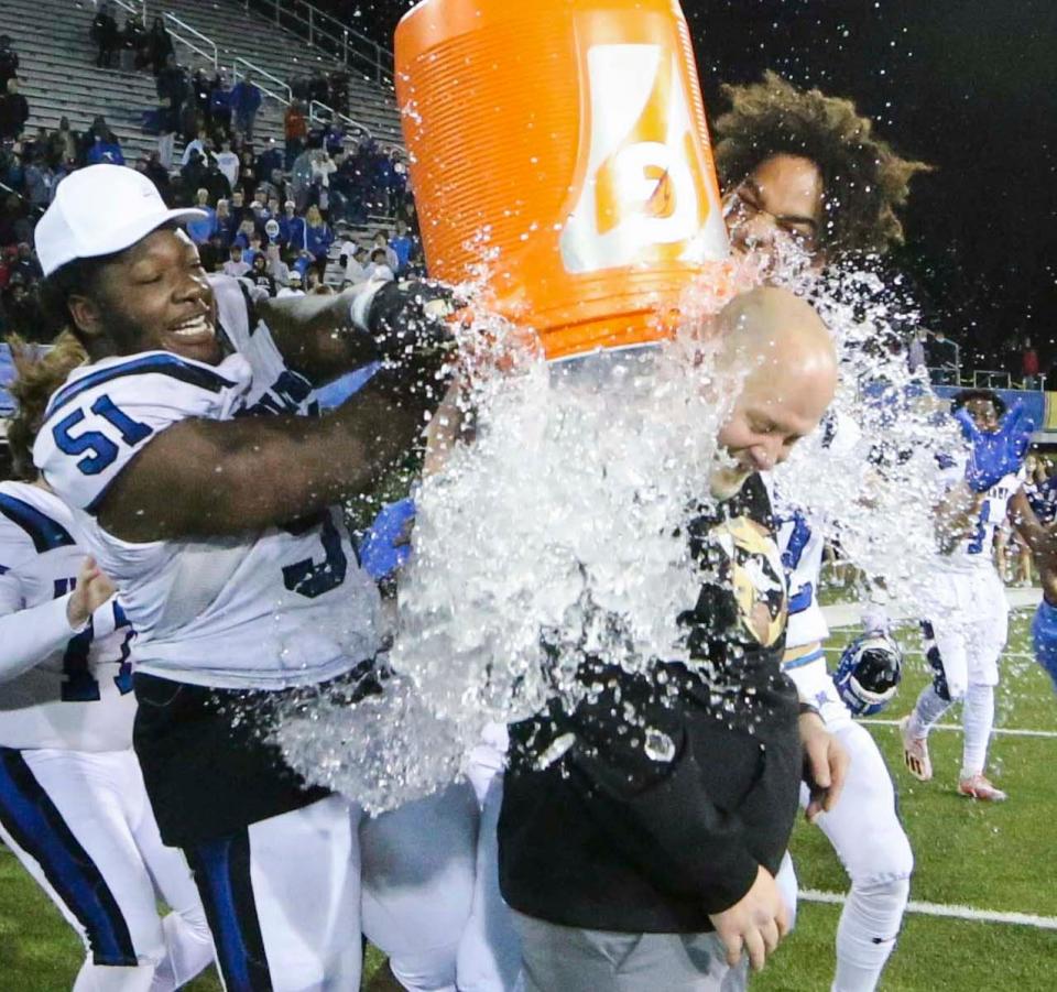 Middletown's Kody Harris-Miller (left) and Braden Davis splash head coach Zach Blum after Middletown's 28-22 win against Smyrna in the DIAA Class 3A state title game, Saturday, Dec, 11, 2021 at Delaware Stadium.