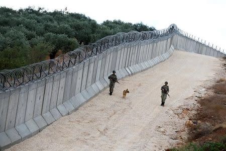 A K9 unit patrol along a wall on the border line between Turkey and Syria, near the southeastern village of Besarslan, in Hatay province, Turkey, November 1, 2016. REUTERS/Umit Bektas/Files