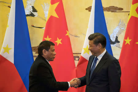 Philippines President Rodrigo Duterte (L) and Chinese President Xi Jinping shake hands after a signing ceremony held in Beijing, China October 20, 2016. REUTERS/Ng Han Guan/Pool