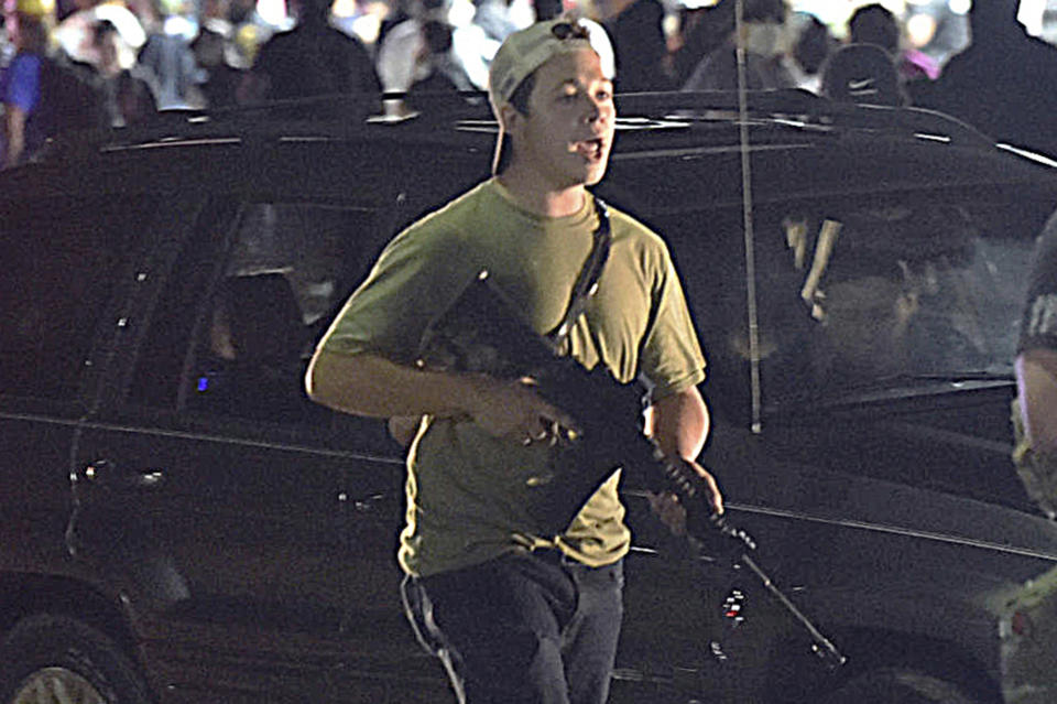 FILE - In this Aug. 25, 2020, file photo, Kyle Rittenhouse carries a weapon as he walks along Sheridan Road in Kenosha, Wis., during a night of unrest following the weekend police shooting of Jacob Blake. Rittenhouse is white. So were the three men he shot during street protests in Kenosha in 2020. But for many people, Rittenhouse's trial will be watched closely as the latest referendum on race and the American judicial system. (Adam Rogan/The Journal Times via AP, File)