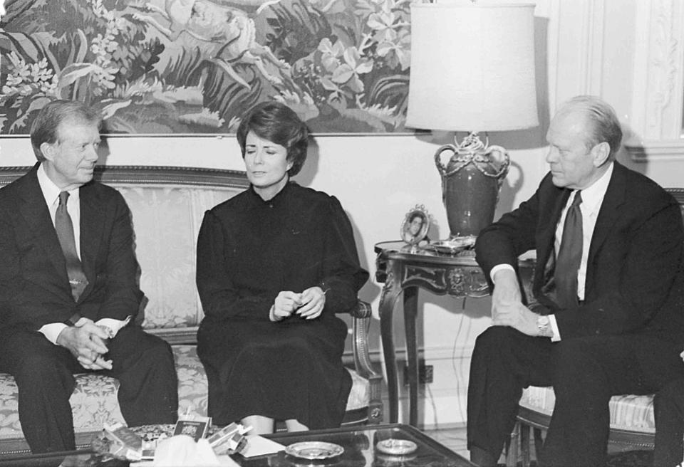 FILE - In this Oct. 9, 1981, file photo, Mrs. Jehan Sadat, widow of assassinated Egyptian President Anwar Sadat, is flanked by U.S. Presidents Jimmy Carter, left, and Gerald Ford, as they meet in her Giza Nile-side home. Jehan Sadat died in Cairo on Friday, July 9, 2021, at the age of 87, Egypt’s President’s office said. (AP Photo, File)