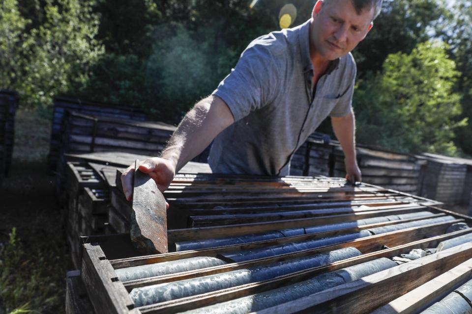 Ben Mossman, CEO of Rise Gold Corporation, pulls pieces of old core samples sitting in storage