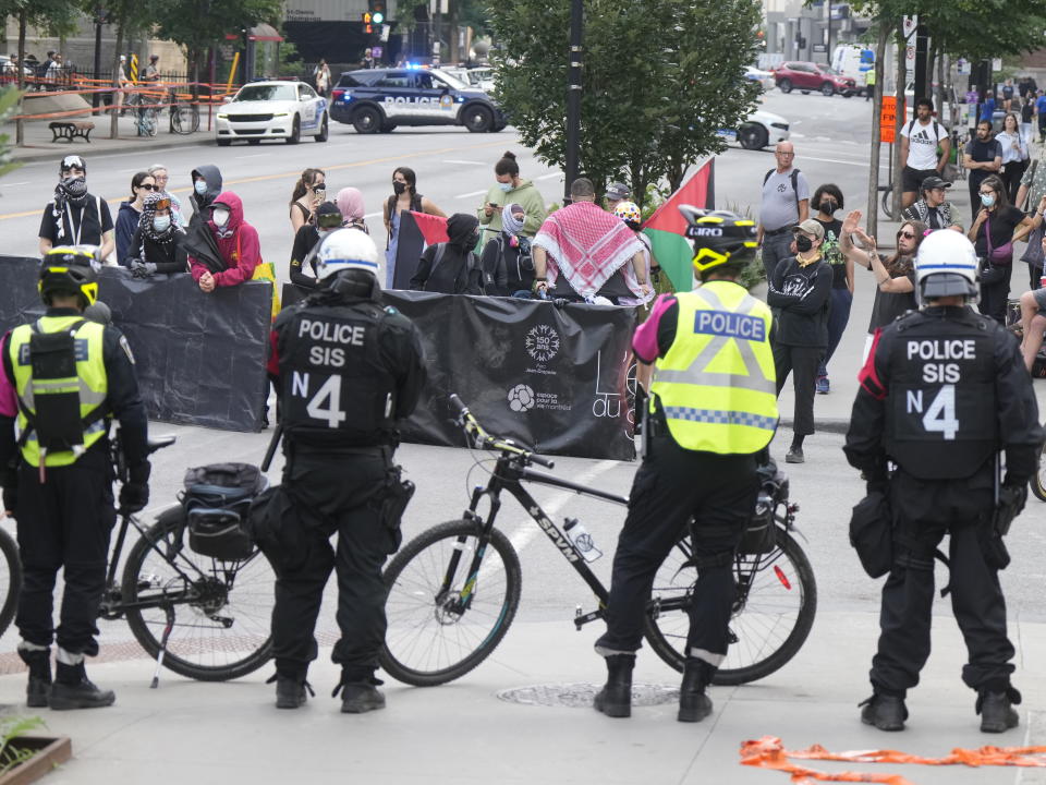 Police keep protesters away from the encampment at McGill University in Montreal, Wednesday, July 10, 2024. The university closed its downtown campus as police descended in large numbers to help clear a pro-Palestinian encampment. (Ryan Remiorz/The Canadian Press via AP)