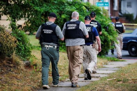 Federal Agents walk near the site where Ahmad Khan Rahami, sought in connection with a bombing in New York, was taken into custody in Linden, New Jersey, U.S., September 19, 2016. REUTERS/Eduardo Munoz