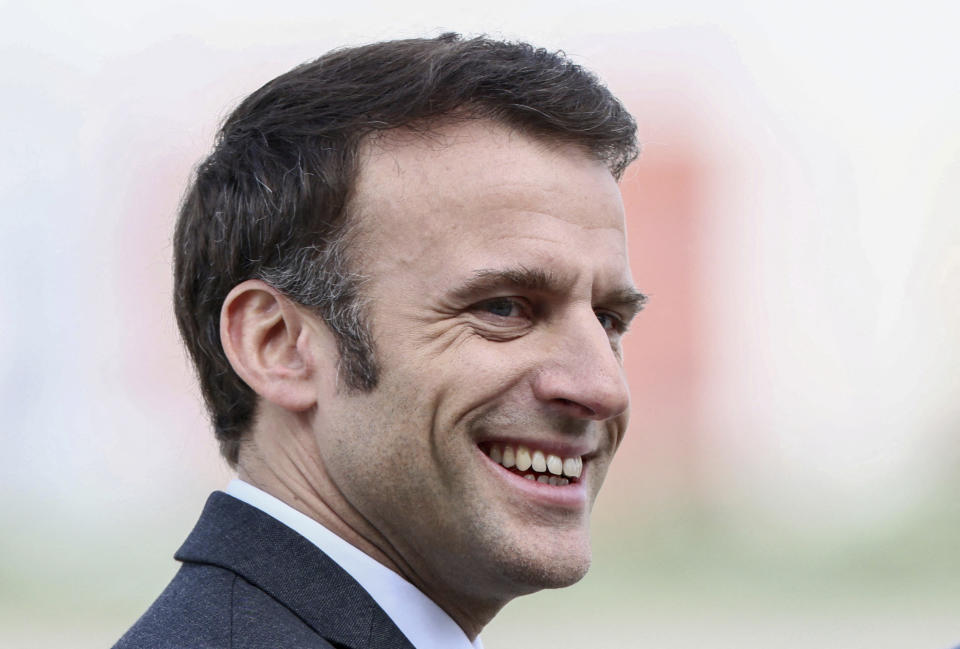 French President Emmanuel Macron smiles as he awaits freed French hostage journalist Olivier Dubois, who was held hostage in Mali for nearly two years, upon his arrival at the military airport in Villacoublay, near Paris, Tuesday, March 21, 2023. (Yves Herman, Pool via AP)