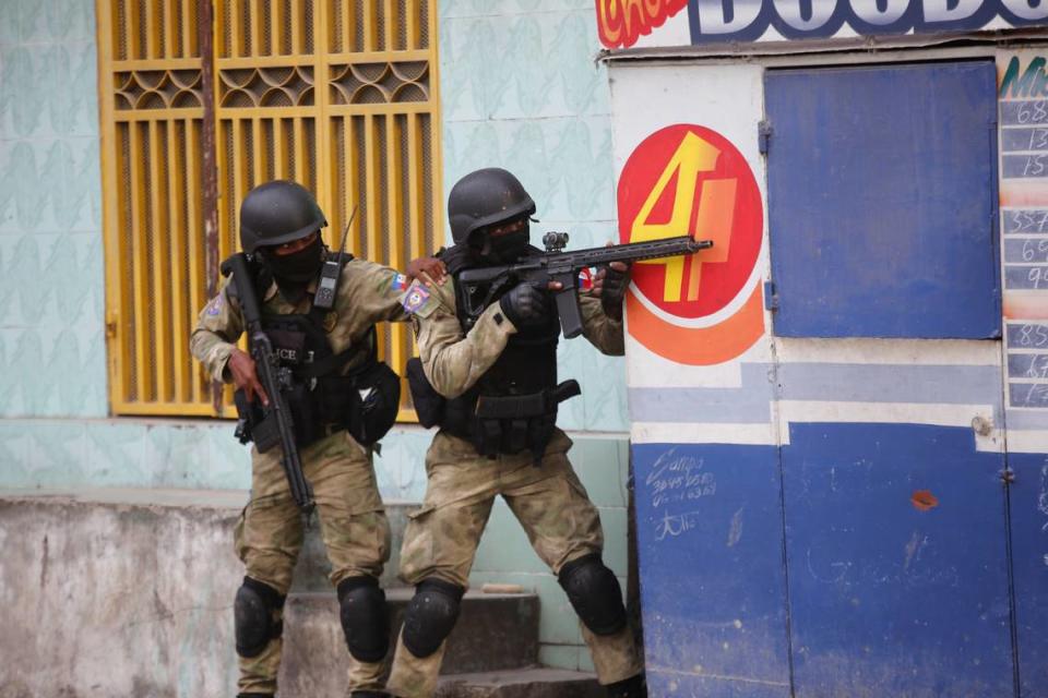 Police take cover during an anti-gang operation at Portail neighborhood in Port-au-Prince, Haiti, Thursday, Feb. 29, 2024. Gunmen shot at the international airport and other targets in a wave of violence that forced businesses, government agencies and schools to close early.