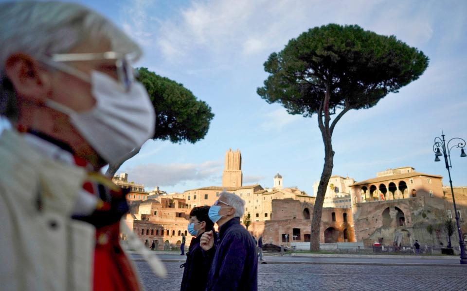People wear masks outside in Rome following the introduction of new rules - AP